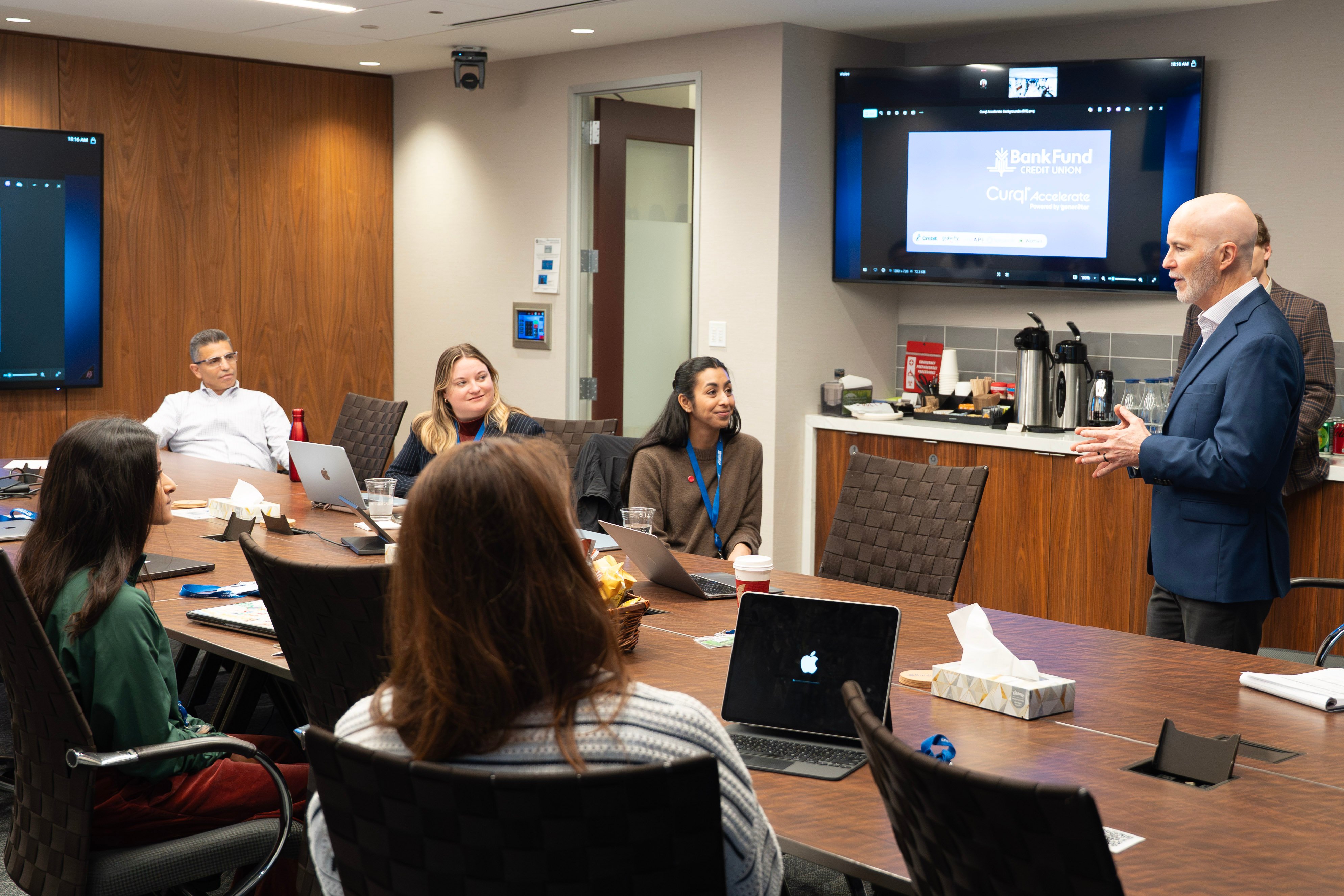 A Curql Accelerate fintech founder listening to the CEO of a Curql credit union during an on-site week